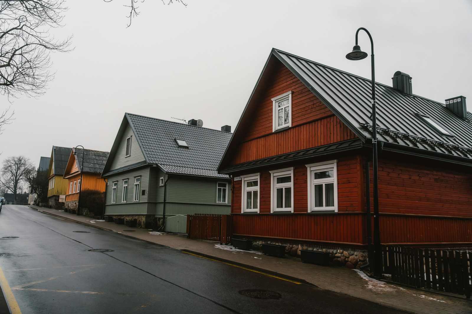 Colorful houses line a wet, overcast street