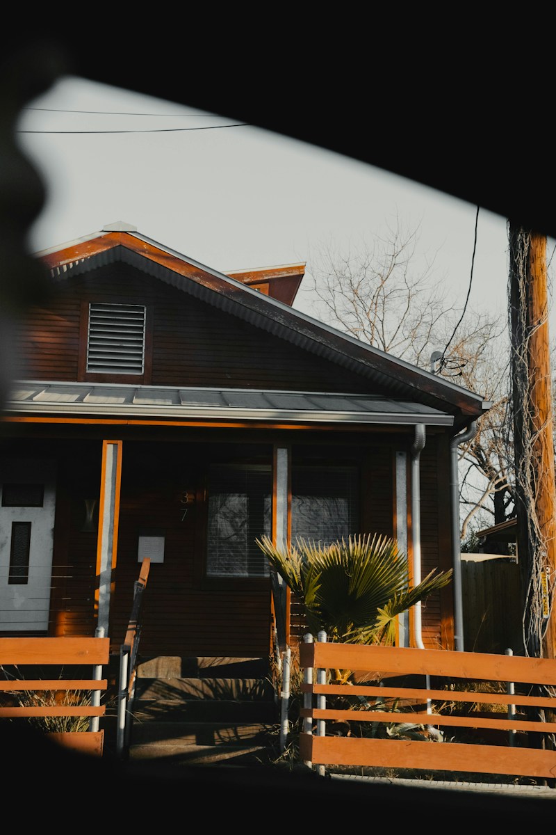 a brown house with a palm tree in front of it