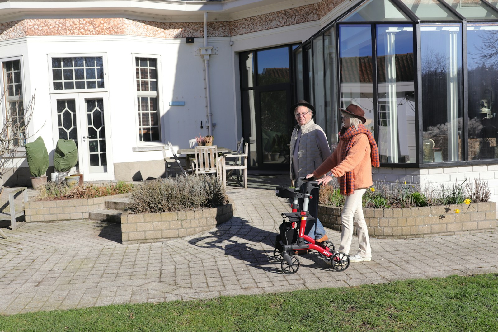 Two people with a walker on a patio