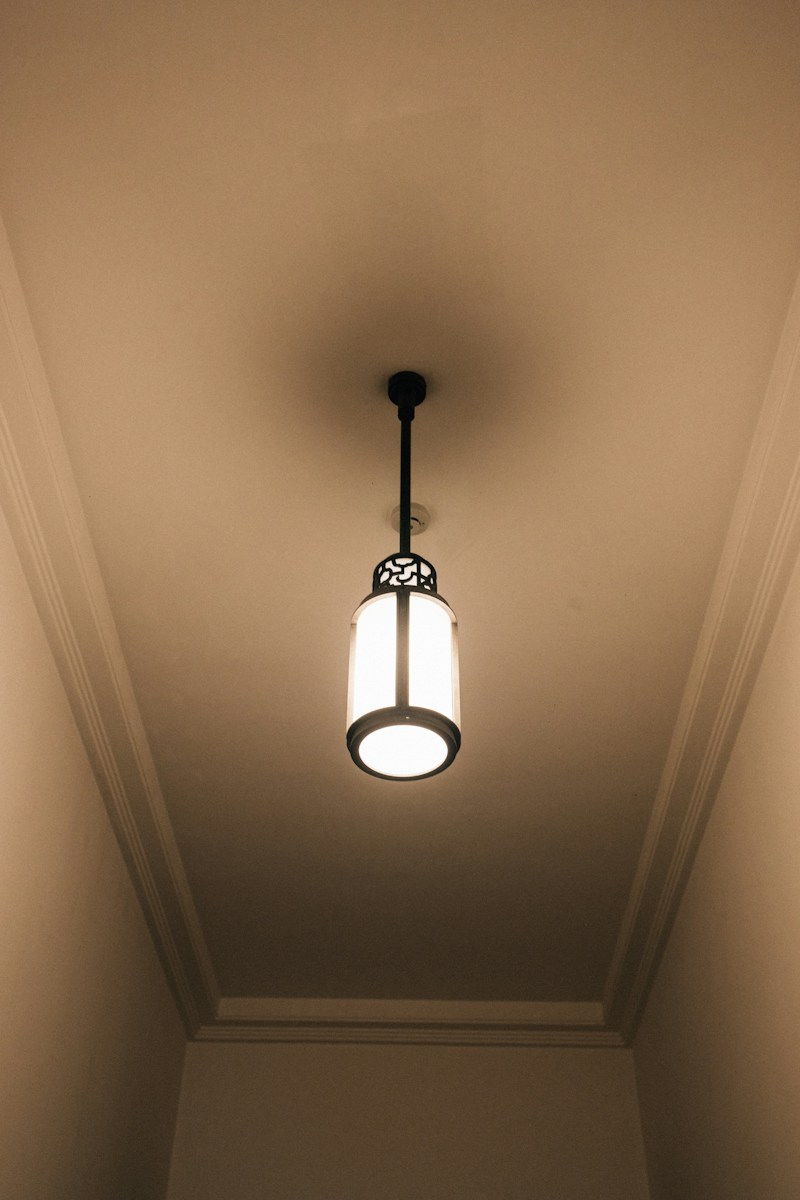 A hanging ceiling light fixture with a decorative shade