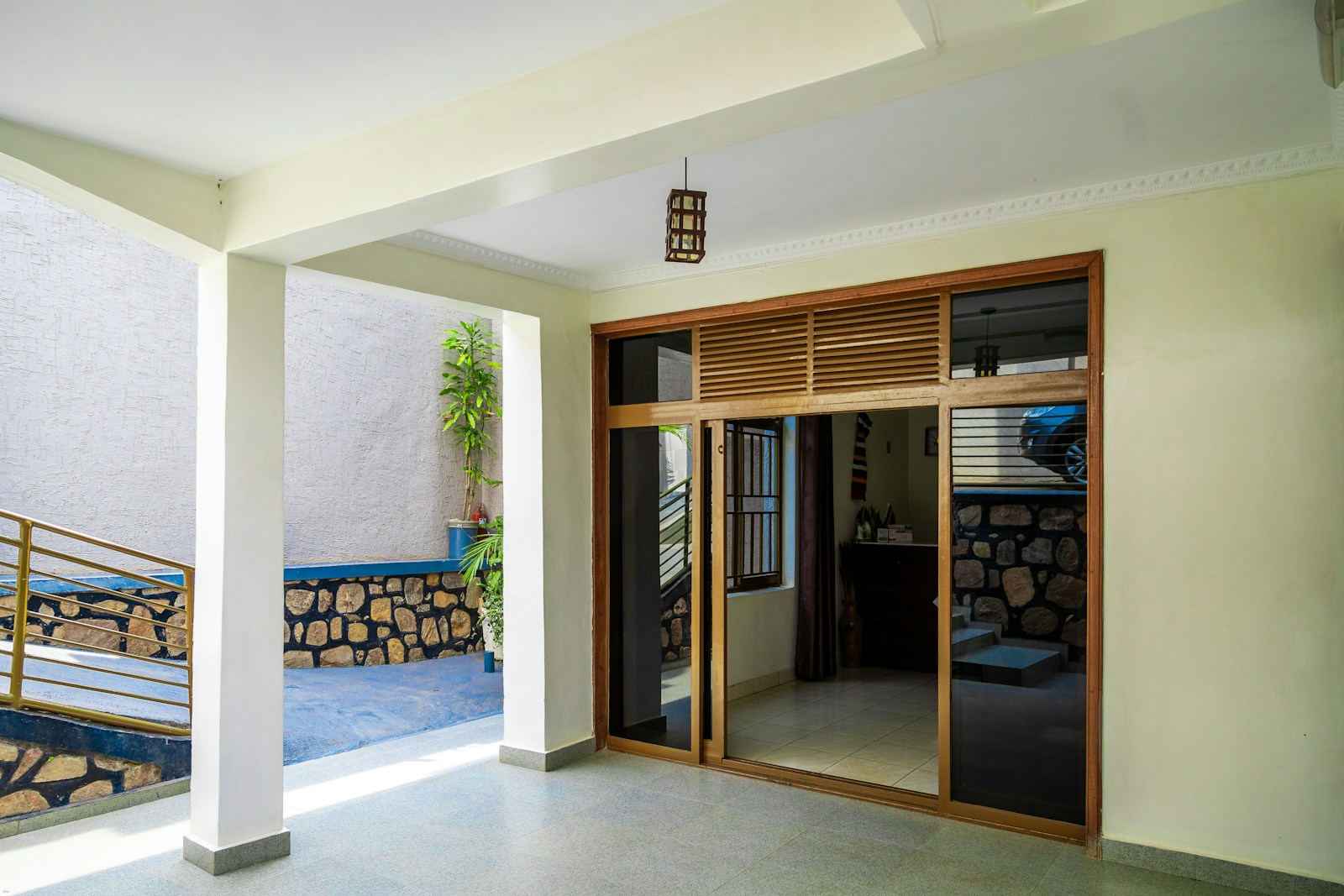 Spacious outdoor patio with wooden doors and white pillars