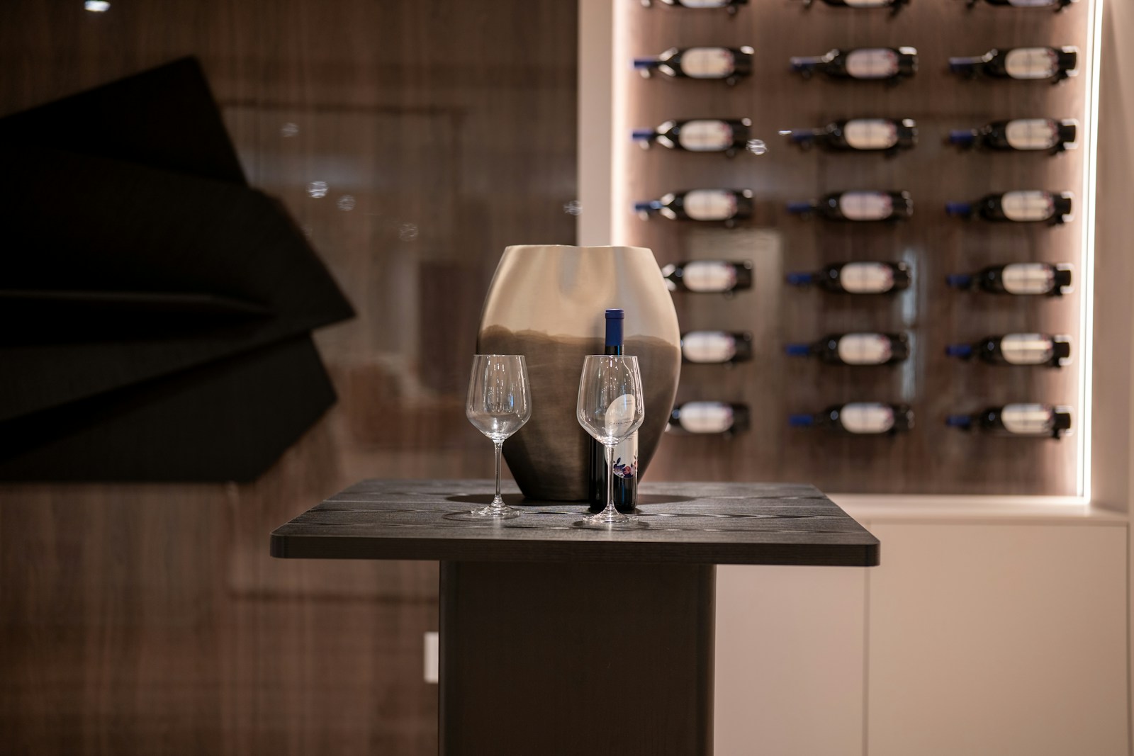 Wine bottle and glasses on table with wine rack