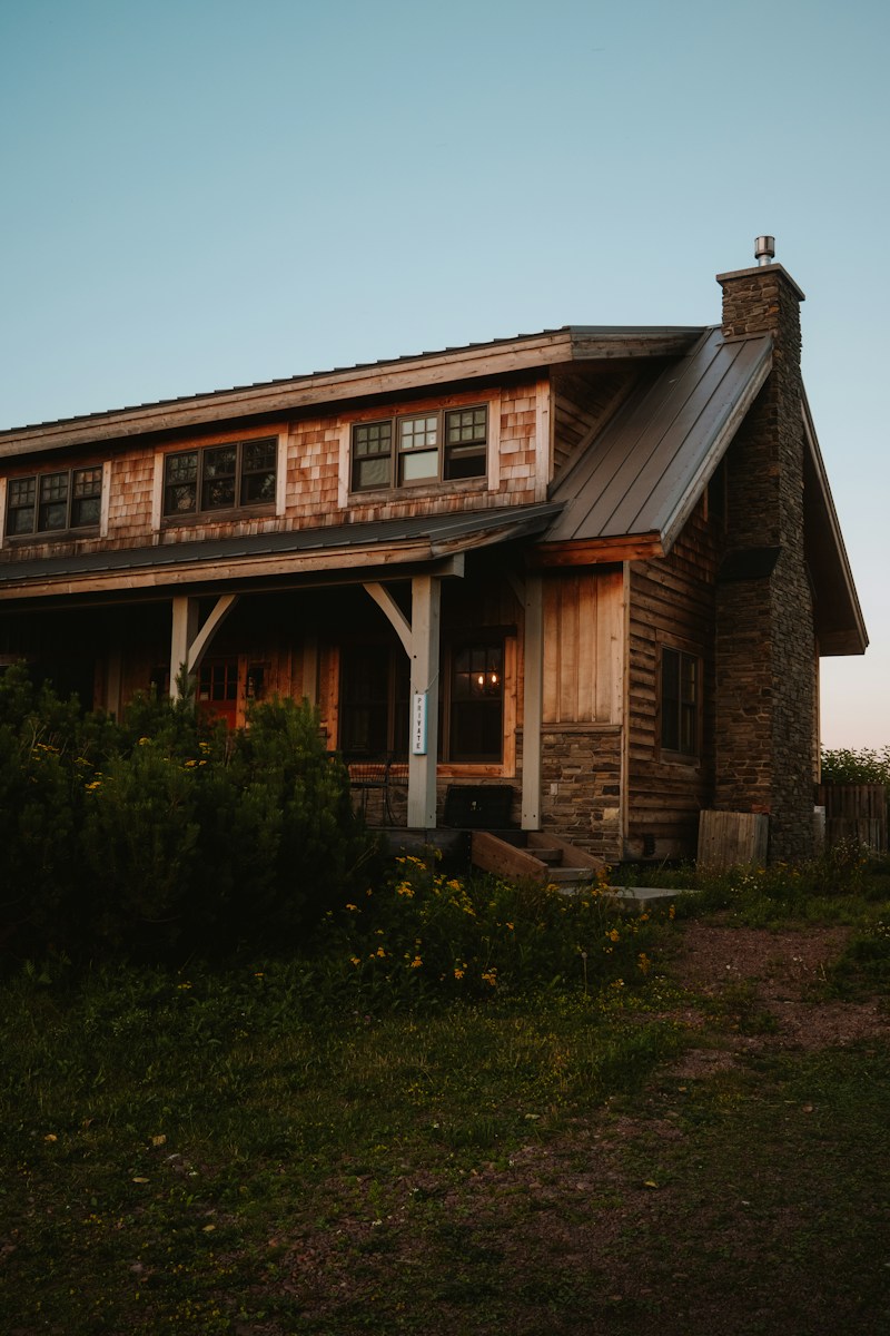 A small wooden house sitting on top of a lush green field