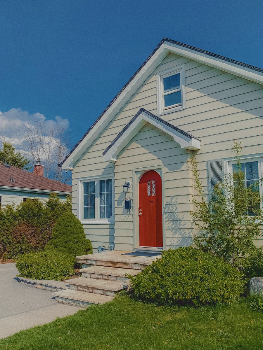 Cozy house with red door under a blue sky