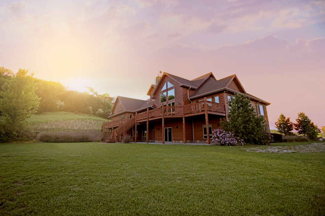 House exterior with green grass field at sunset