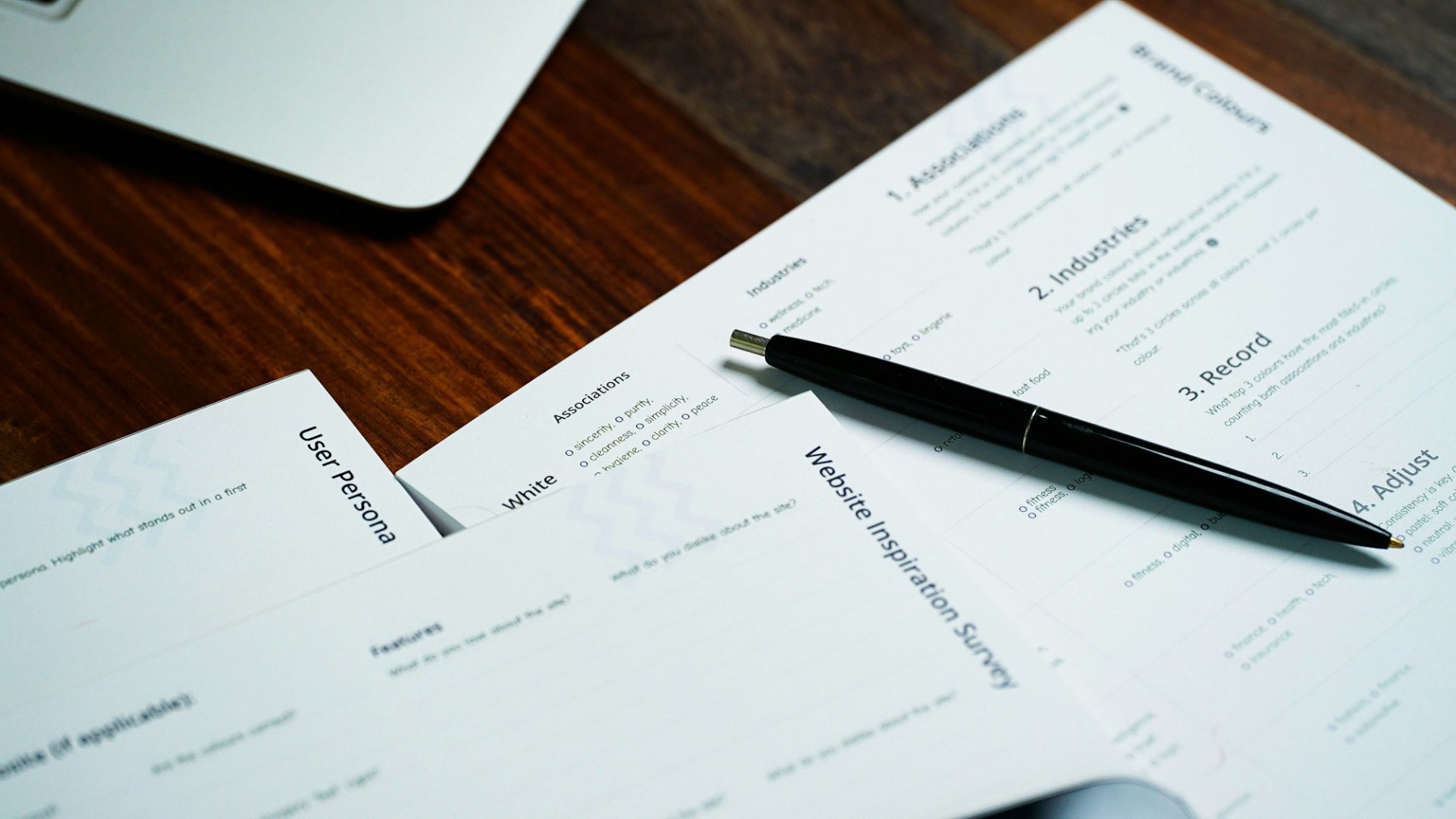 A pen sitting on top of a pile of papers. Photo by 2H Media on Unsplash.