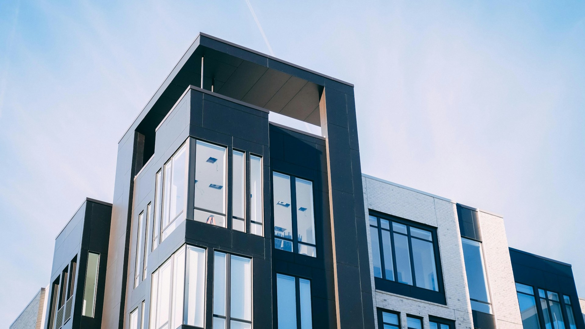 A modern glass and concrete building seen from below. Photo by Luke van Zyl on Unsplash.